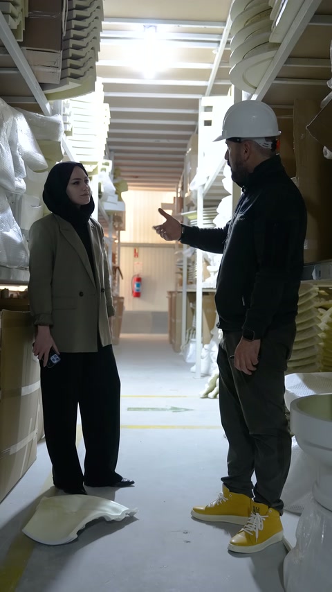 Baretli görevli üretim alanında ürün özelliklerini el hareketleriyle açıklıyor