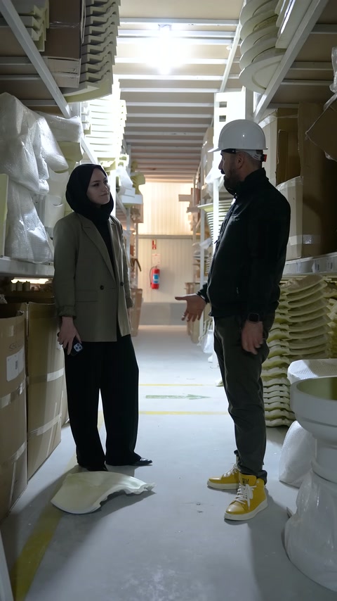 İki kişi raflardaki farklı süsleme elemanlarını birlikte inceliyor