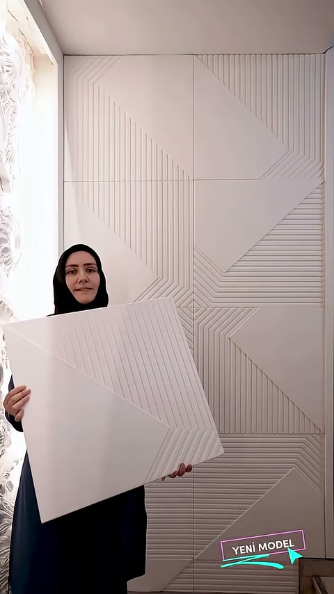 Açılı tutulan dekoratif panel, duvardaki tekrar eden modüllerle eşleşiyor.