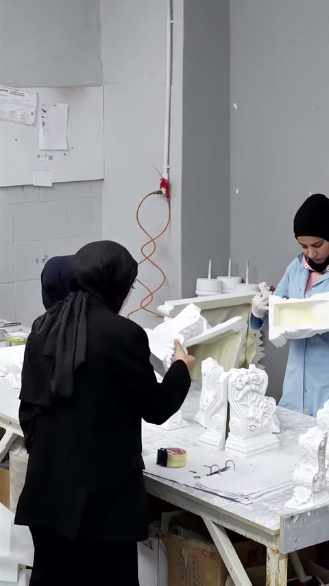 Sunucu elindeki beyaz dekoratif parçayı tezgâh başında gösteriyor.