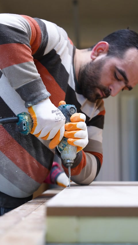 Usta tabla kenarını elektrikli el aletiyle biçimlendiriyor