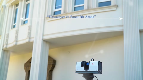 Tripodlu tarayıcı, dekoratif sütunlarla çevrili üst cepheye yöneliyor.