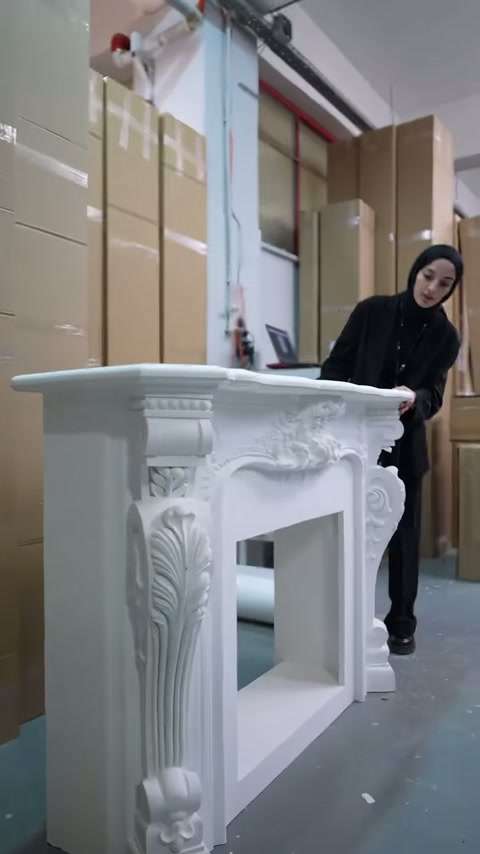 Sunucu, oyma detaylı şömine çerçevesinin üst bölümünü inceliyor.