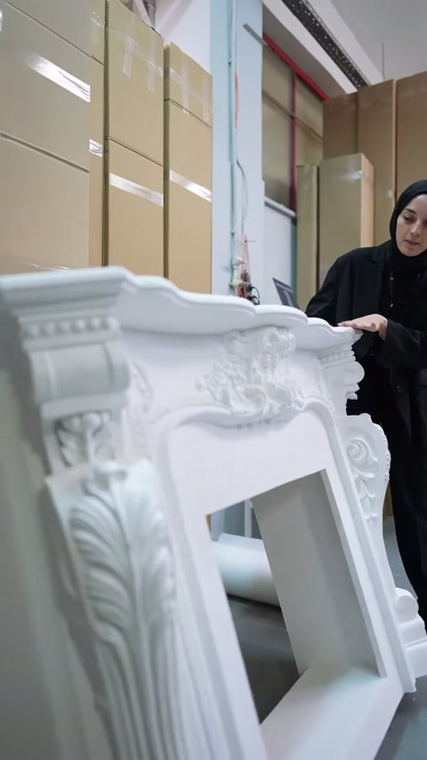 Şömine çerçevesinin taç bölümü ve kabartmalı süsleri öne çıkıyor.