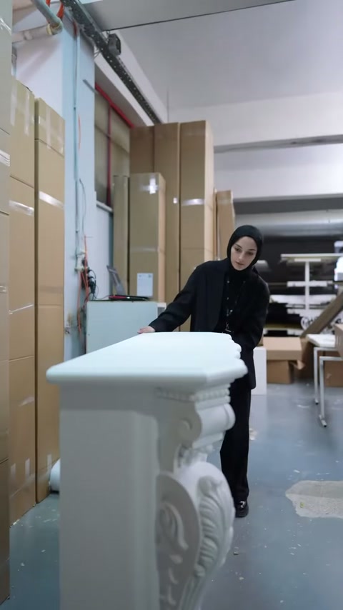 Sunucu, şömine yanındaki düz beyaz dekoratif parçayı işaret ediyor.