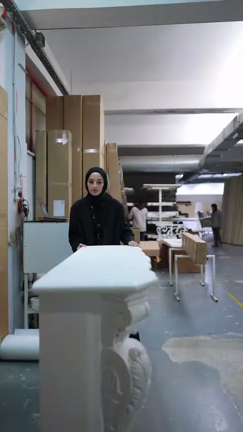 Sunucu, sade üst tablalı şömine modelinin arkasında konuşuyor.