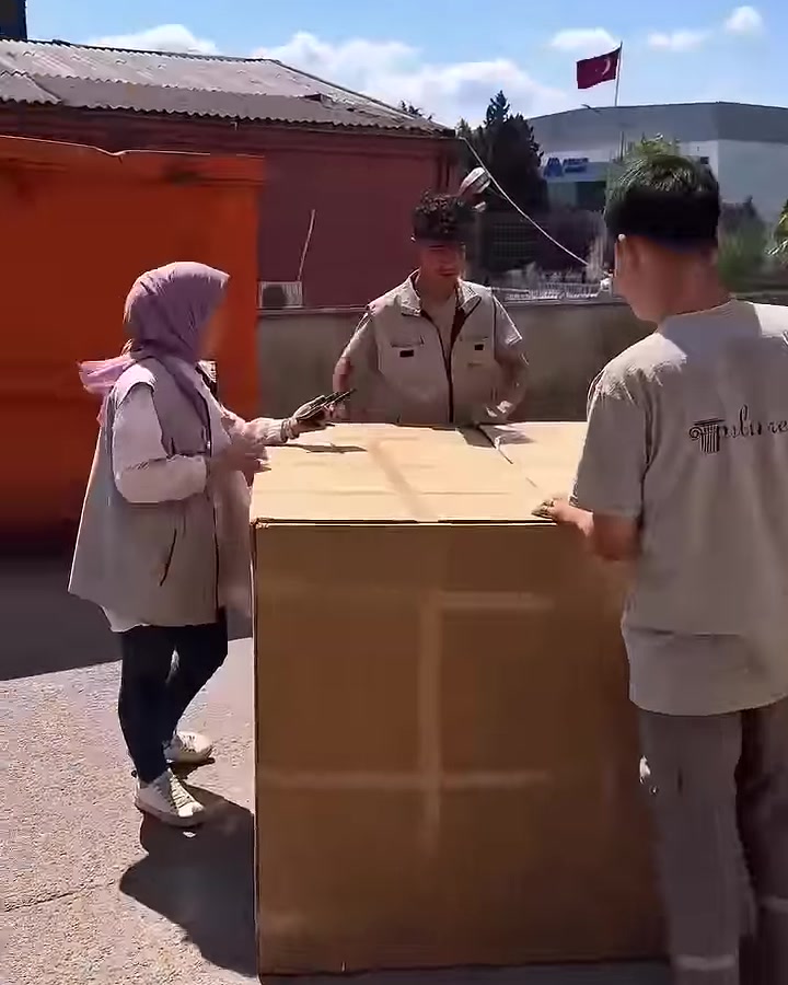 Sevkiyat alanında büyük karton ambalaj kalite kontrolü için inceleniyor.
