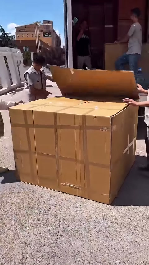 Çalışanlar ambalajın karşılıklı kapaklarını dışarı doğru ayırıyor