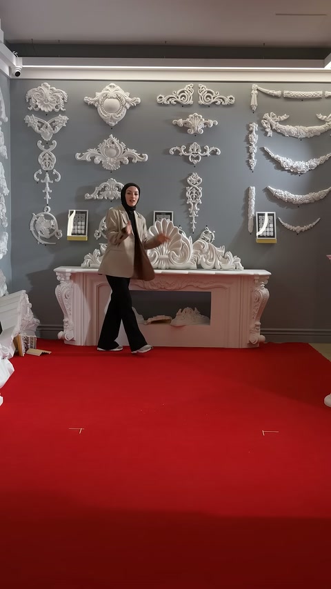 Dekoratif ürünlerle çevrili sunucu, showroom alanında tanıtıma devam ediyor.