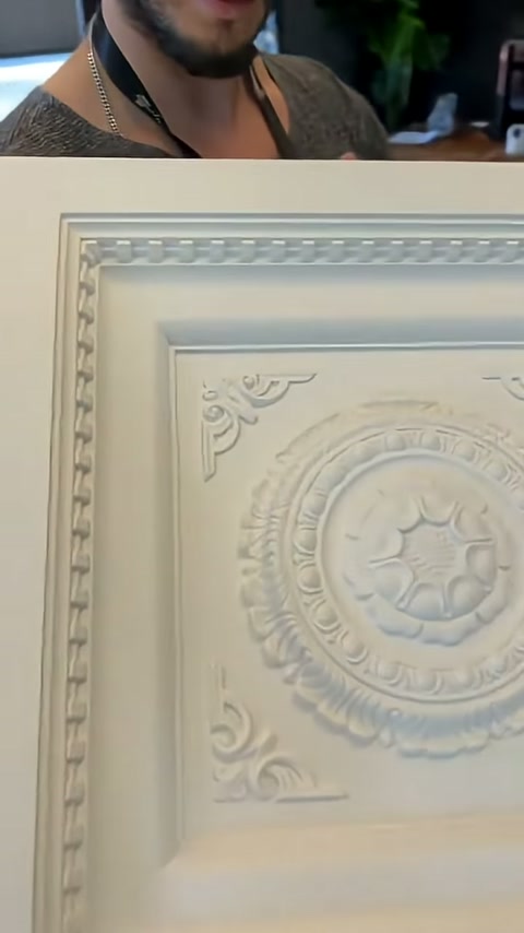 Panelin üst kenarındaki dişli bordür ve merkez madalyonu kadrajda beliriyor.