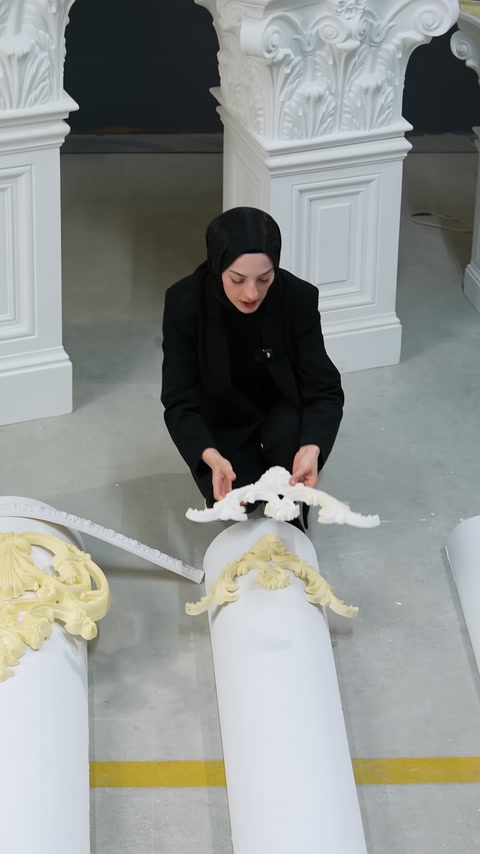 Beyaz kıvrımlı süsleme kavisli gövdenin üzerine yeniden yerleştiriliyor.