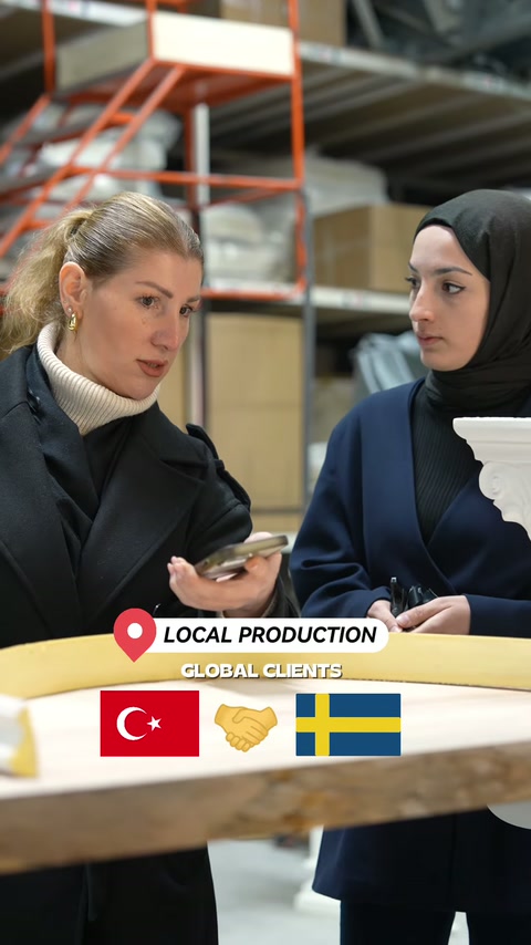Masa üzerindeki geniş kavisli parça showroom ortamında değerlendiriliyor