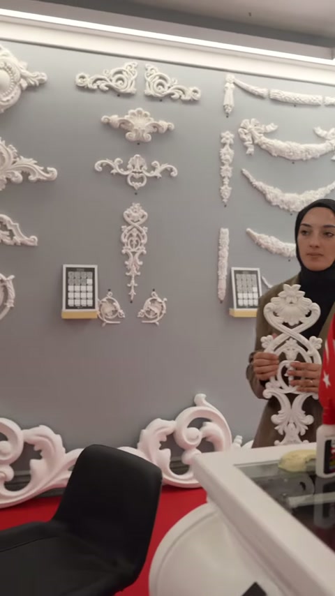 Sergi duvarında farklı biçimlerde beyaz kabartmalı süslemeler sıralanıyor