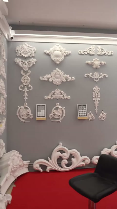 Gri duvarda çiçekli, kıvrımlı ve köşe biçimli motifler bulunuyor