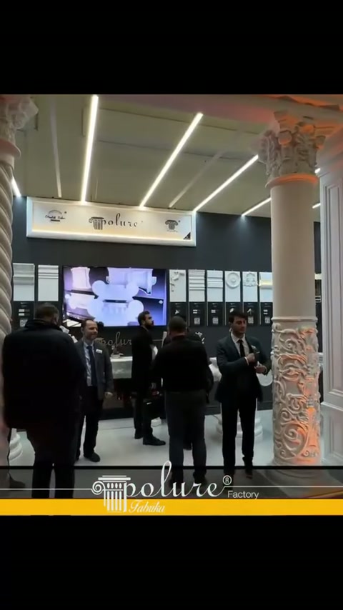 Klasik ve burgulu sütunların çevrelediği stantta ziyaretçiler dolaşıyor