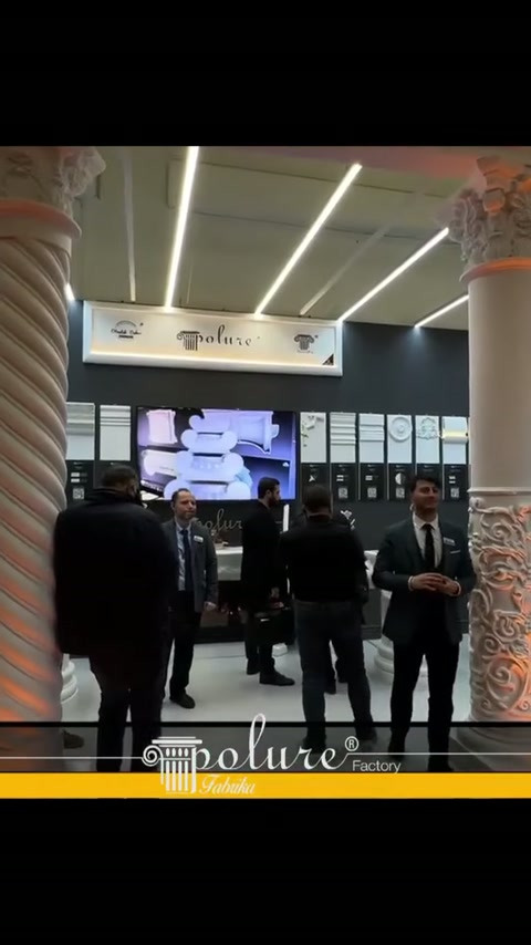 Burgulu sütun önünde stand görevlileri ve duvar numuneleri görülüyor