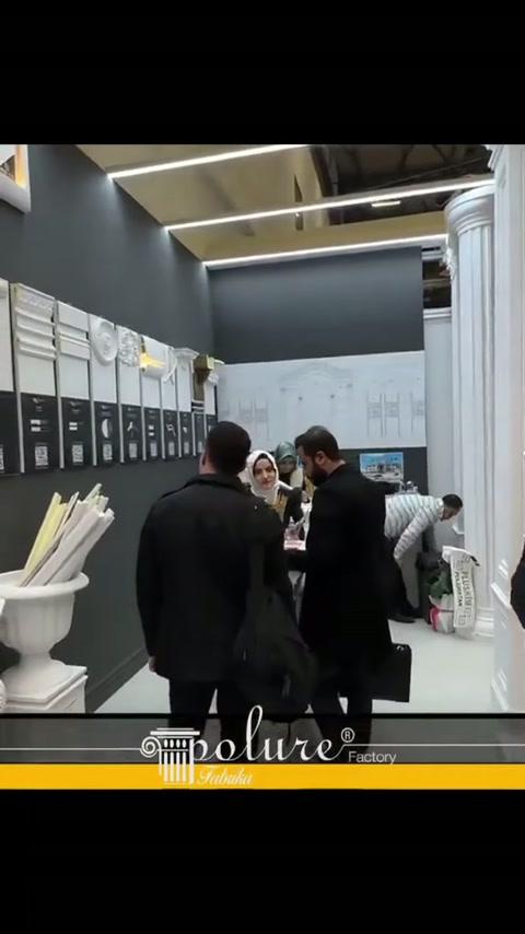 Sütunlu teşhir bölümünde ziyaretçiler duvar örneklerine yakından bakıyor