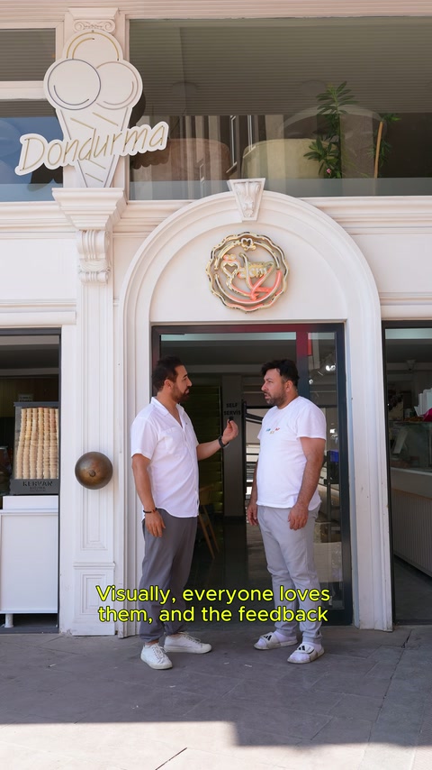 Tamamlanmış pastane girişindeki beyaz kemer çerçevesi iki kişinin arkasında görülüyor.