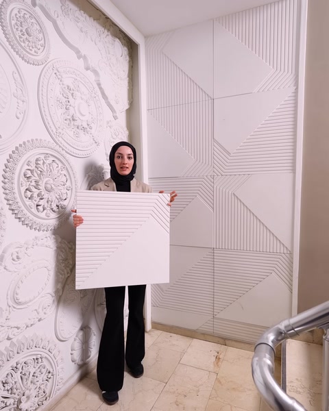 Kadın kartonpiyerli mekanda kare desenli paneli sergiliyor