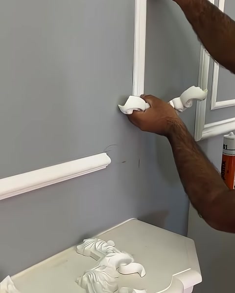 Usta dekoratif köşe parçasını yatay ve dikey çıtalara yaklaştırıyor.