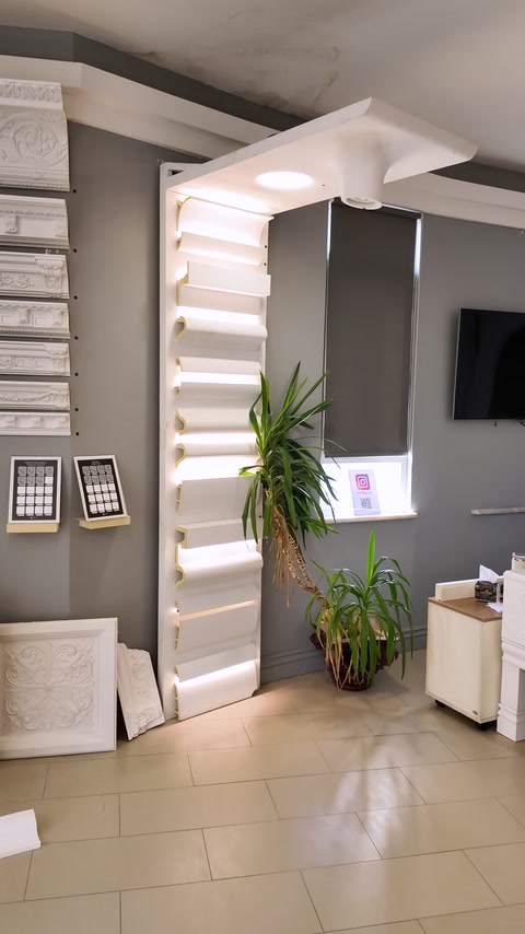 Aydınlatmalı profil örnekleriyle çevrelenmiş showroom sergileme duvarı