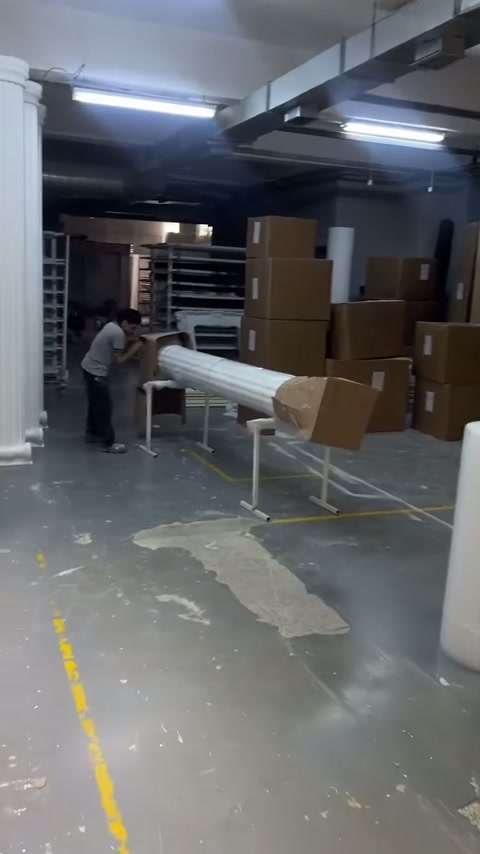 Paketlenmiş sütun gövdesi metal sehpalar üzerinde işlem için bekliyor