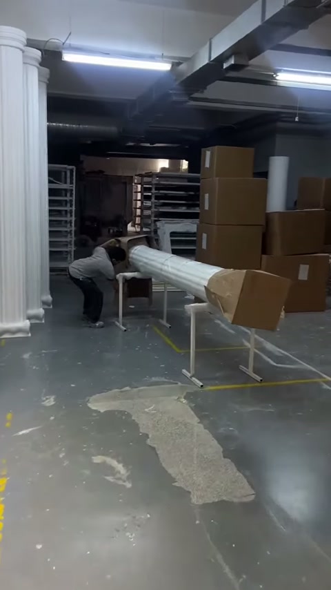 Çalışan uzun sütunun uç kısmındaki karton korumayı açıyor
