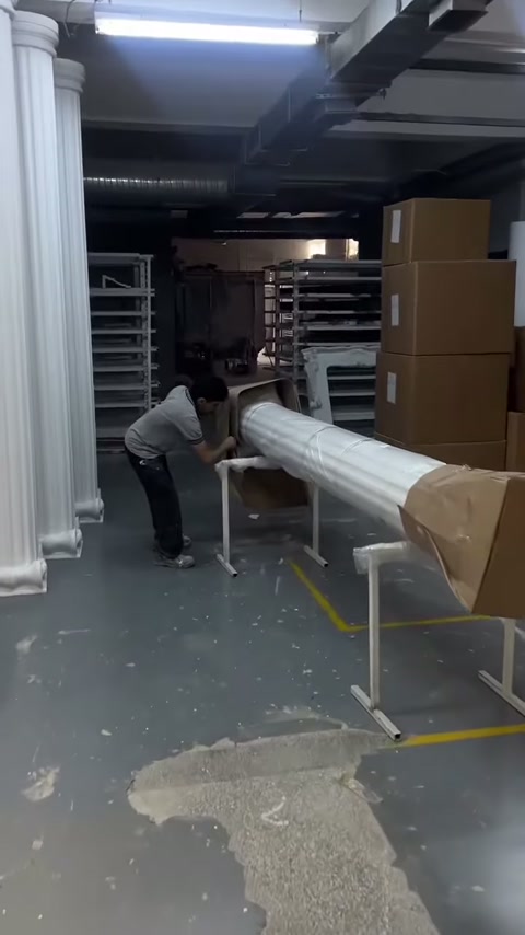 Usta sehpaya yerleştirilen sütunun karton kaplamasını söküyor