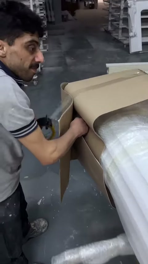 Usta paketlenmiş sütunun ucundaki karton katman üzerinde çalışıyor