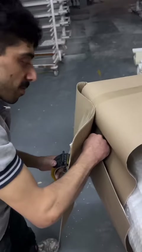 Çalışan karton korumayı keserken yivli sütun yüzeyi kısmen görünüyor