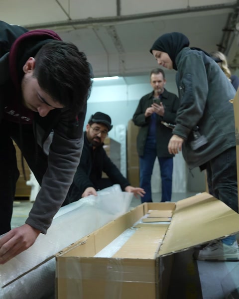 Çalışan paketleme masasında ürünü streç filmle sarıyor