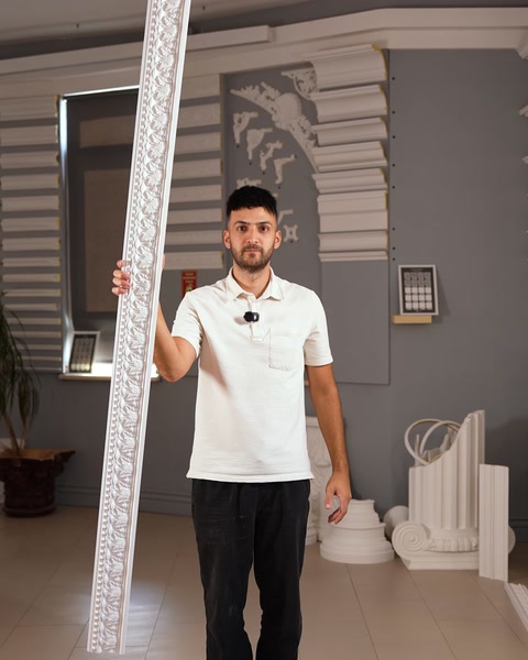 Düz sert bordür profili elde dikey tutuluyor, showroom içinde.