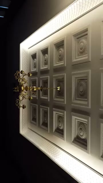Tamamlanmış tavan uygulamasında sıralı kare paneller avizeyi çevreliyor