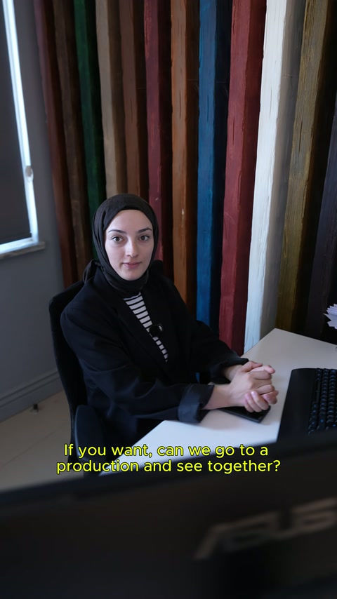 Üretim sürecini anlatan kadın çalışan masa başında kameraya konuşuyor