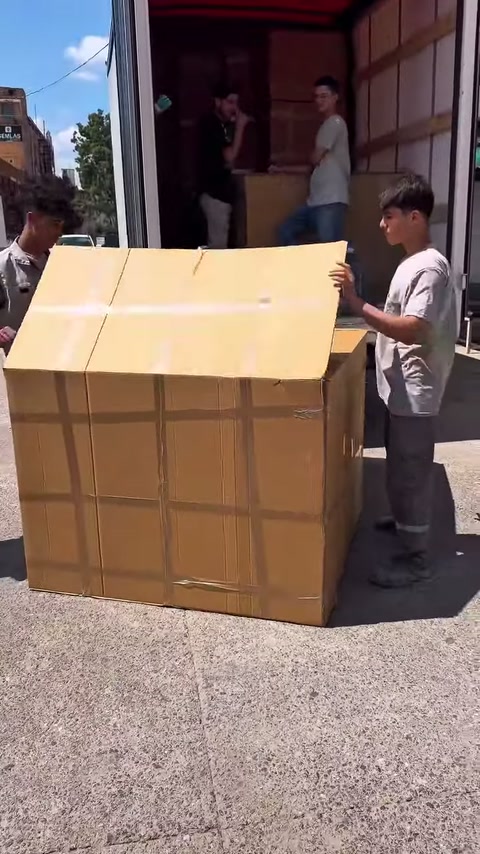 Karşılıklı çalışanlar ikinci karton kapağı birlikte yukarı kaldırıyor