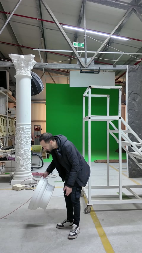 Usta atölye zeminindeki kavisli dekoratif parçayı kaldırmak için eğiliyor