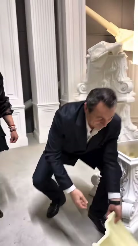 Dekoratif kaide yanında eğilen müşteri, açık renkli parçayı inceliyor