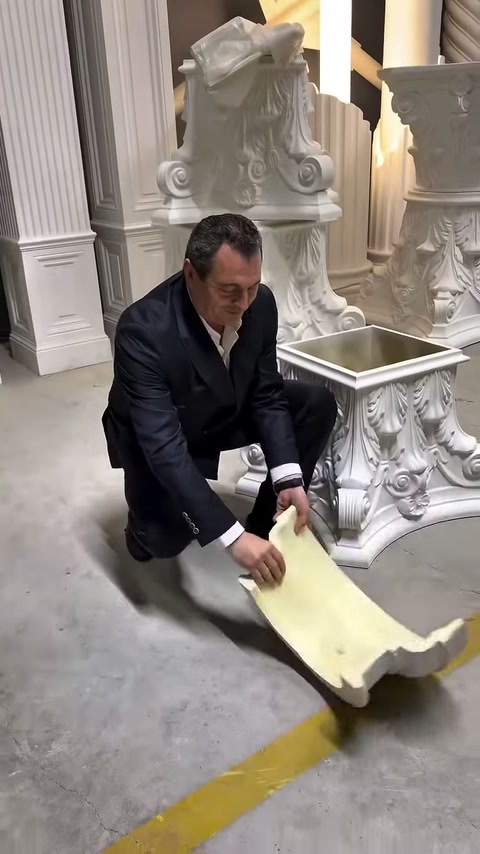 Müşteri, geniş kavisli dekoratif profil örneğini showroom zemininde tutuyor