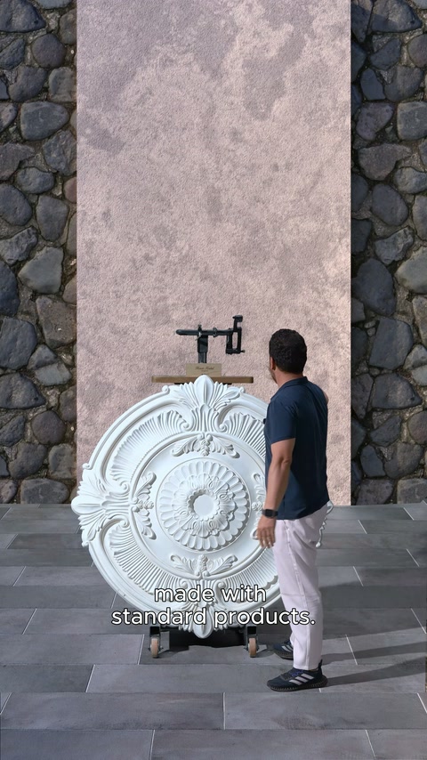 İşlemeli tavan göbeği taş kaplı uygulama duvarına getiriliyor.