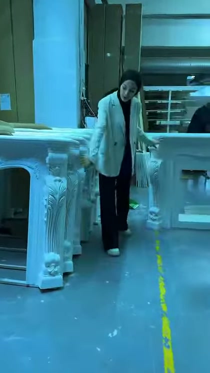Sunucu klasik motifli şömine ayaklarının yanında modelleri anlatıyor