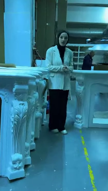 Sunucu geniş üst tablalı şömine modeline eliyle işaret ediyor
