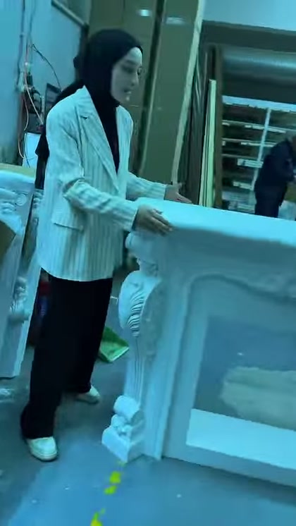 Sunucu beyaz şömine çerçevesinin geniş üst tablasını yakından gösteriyor