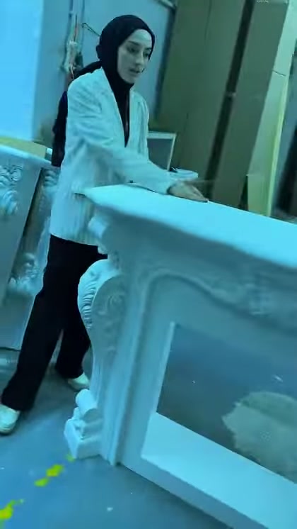 Beyaz şömine çerçevesinin kalın üst tablası atölyede yakından görülüyor