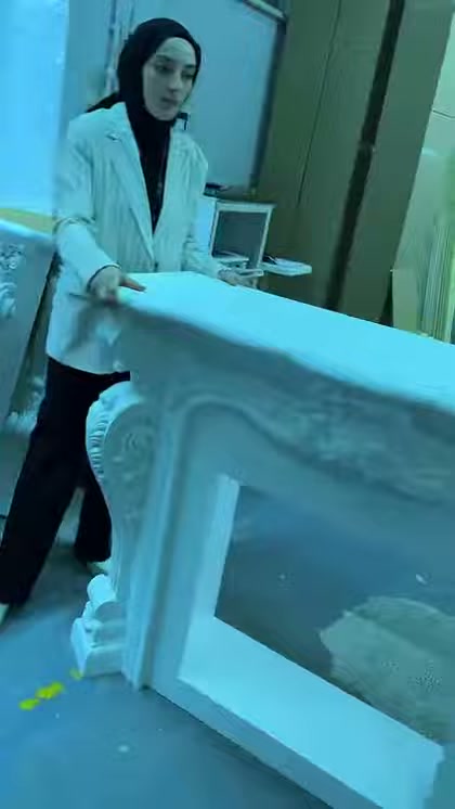 Sunucu sade gövdeli şömine modelinin önünde ayrıntıları gösteriyor