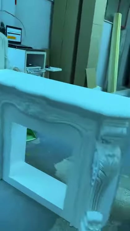 Beyaz şöminenin kabartmalı yan ayağı ve üst köşesi inceleniyor