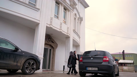 Beyaz söve ve dış cephe silmeleriyle donatılmış bina girişi