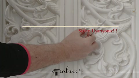 Parmak, poliüretan paneldeki oyma motif ile düz şeridi belirtiyor