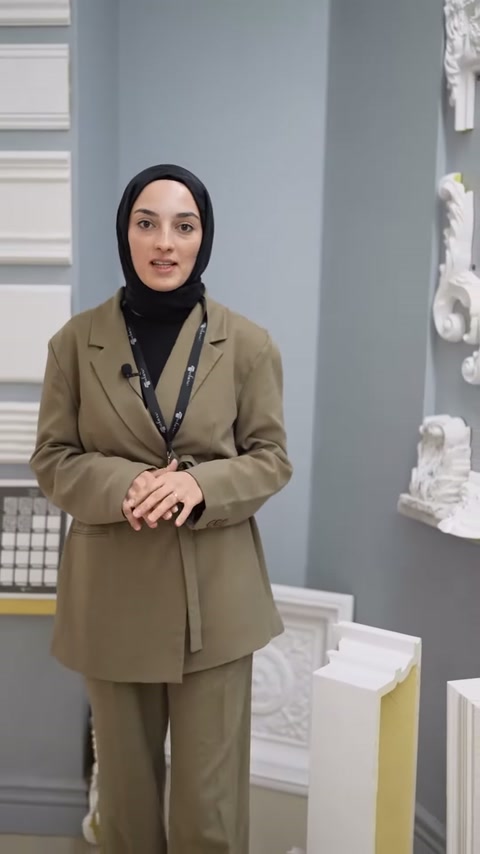 Sunucu köşe motifleriyle çevrili showroom bölümünde konuşuyor.