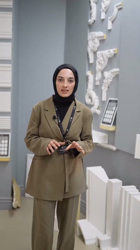 Sunucu farklı kalınlıklardaki beyaz çıtaların önünde açıklama yapıyor.