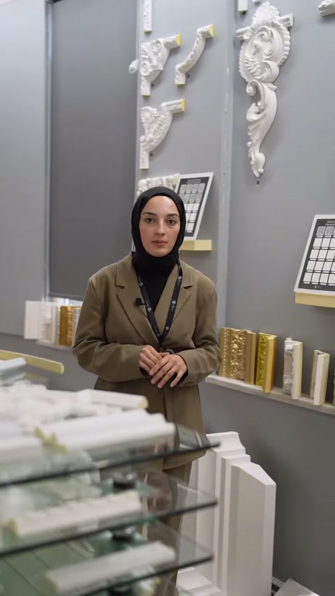 Sunucu ellerini tezgâha dayayarak dekoratif çıtaları tanıtıyor.